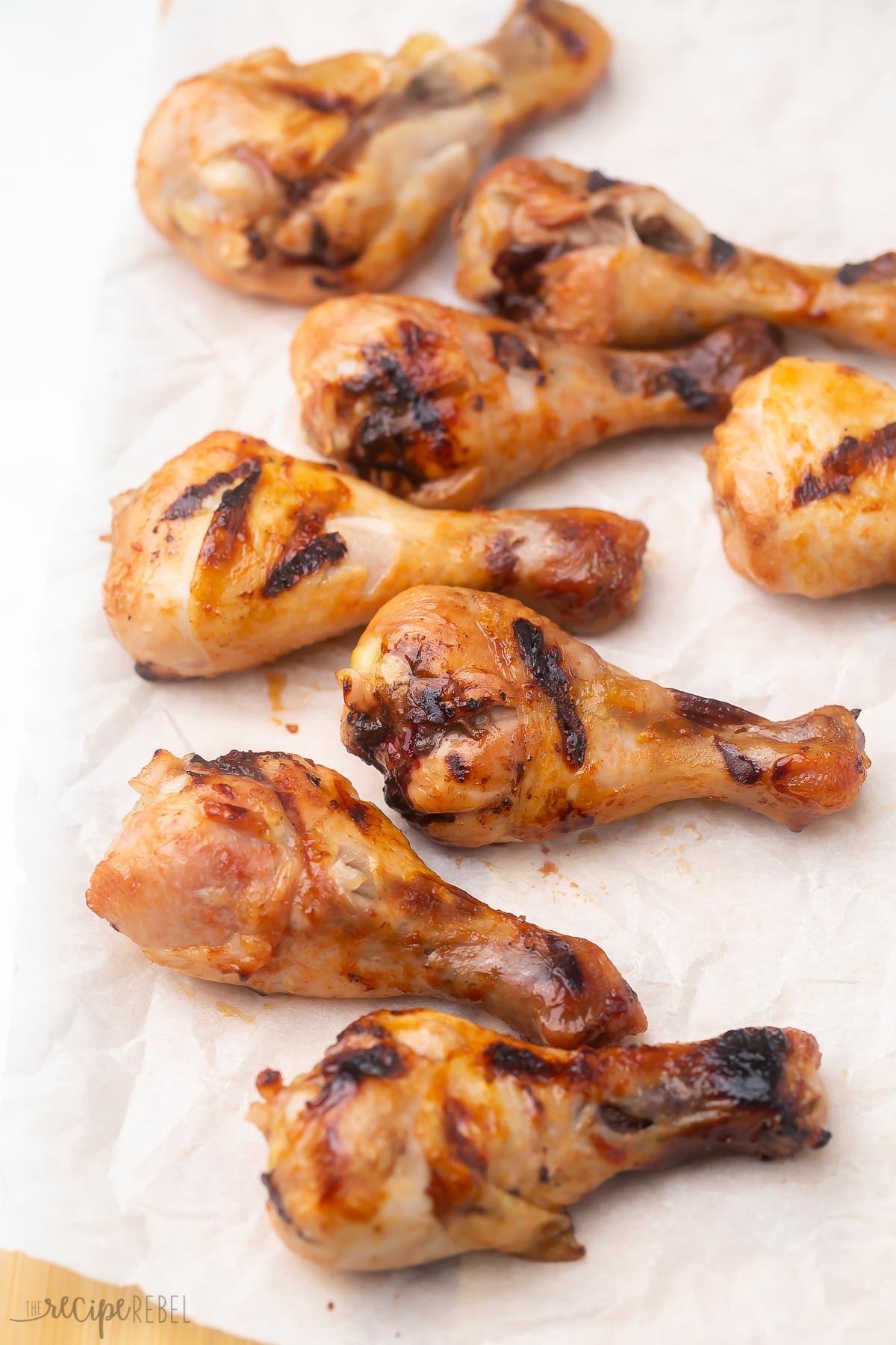 grilled chicken drumsticks lying on parchment paper without glaze.