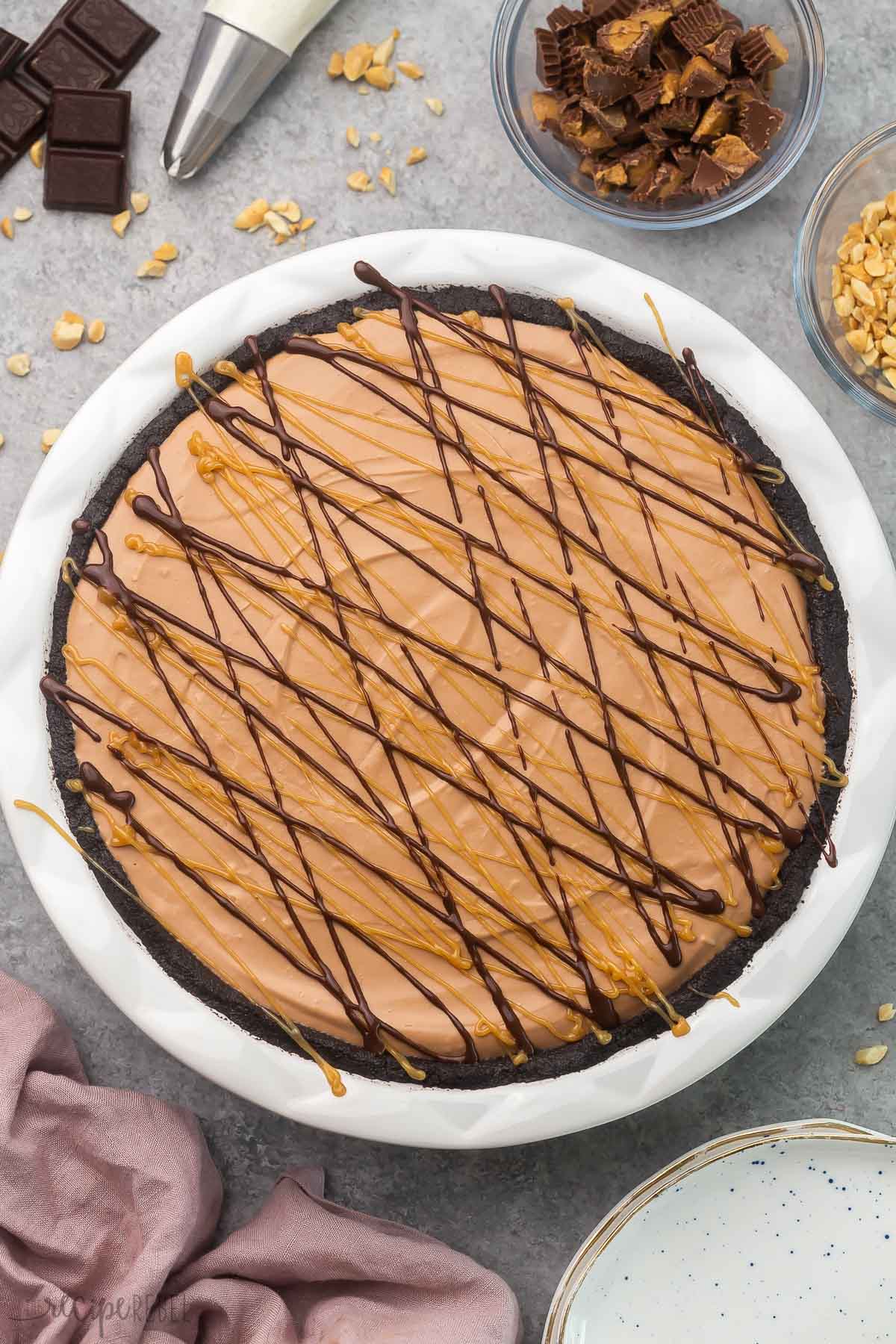 overhead shot of no bake chocolate peanut butter pie with topping beside it.