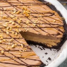 chocolate peanut butter pie in white dish with one piece missing.