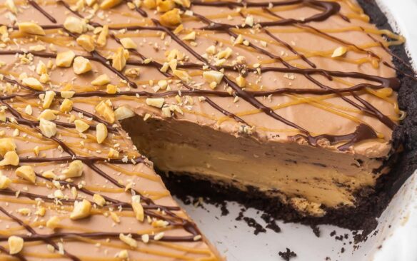 chocolate peanut butter pie in white dish with one piece missing.