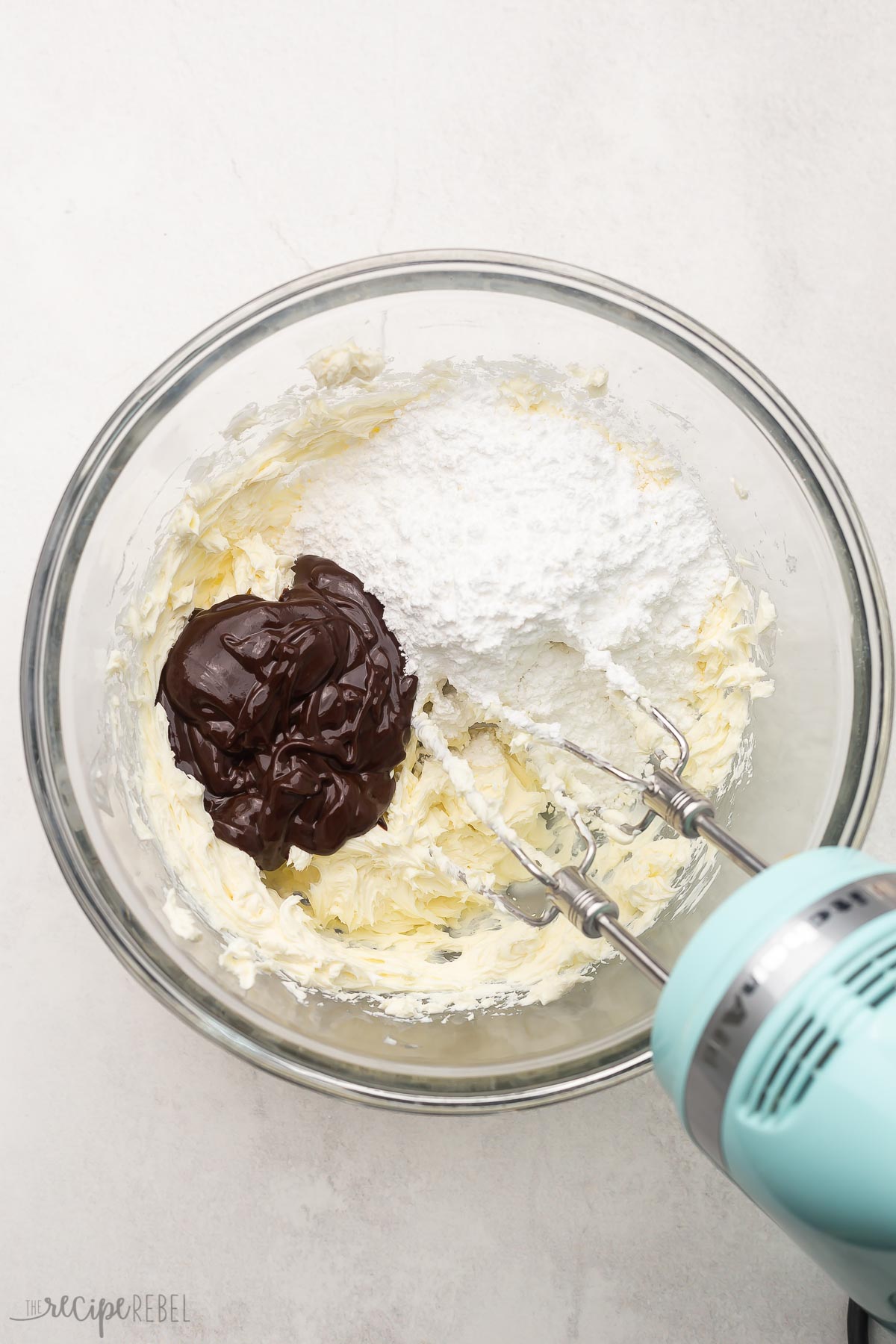 glass bowl and mixer with unmixed chocolate filling ingredients.