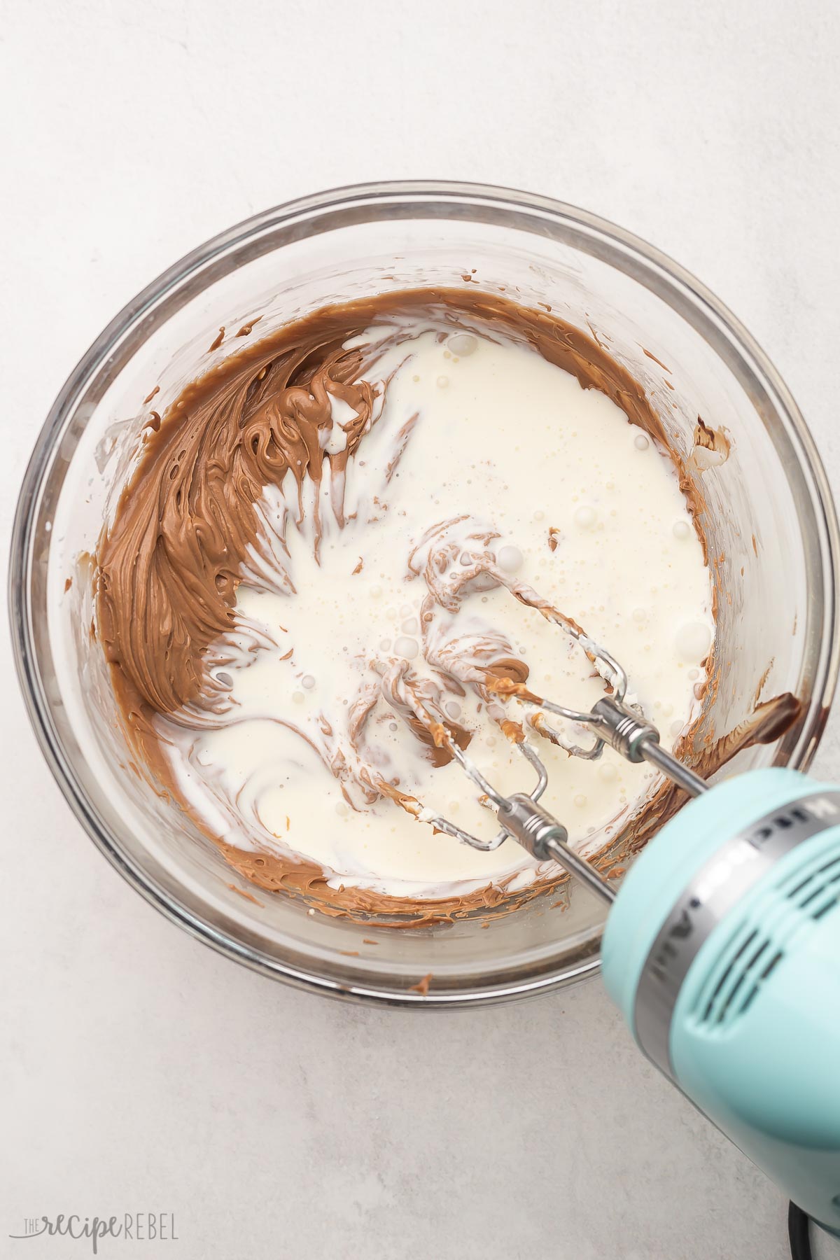 glass bowl with mixed chocolate filling and cream on top.