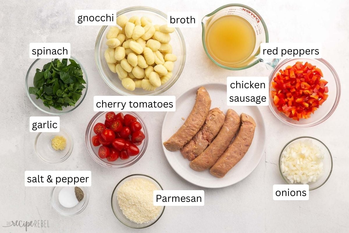 Top view of ingredients needed to make Gnocchi with Sausage and Tomatoes in small bowls with labels on them. 