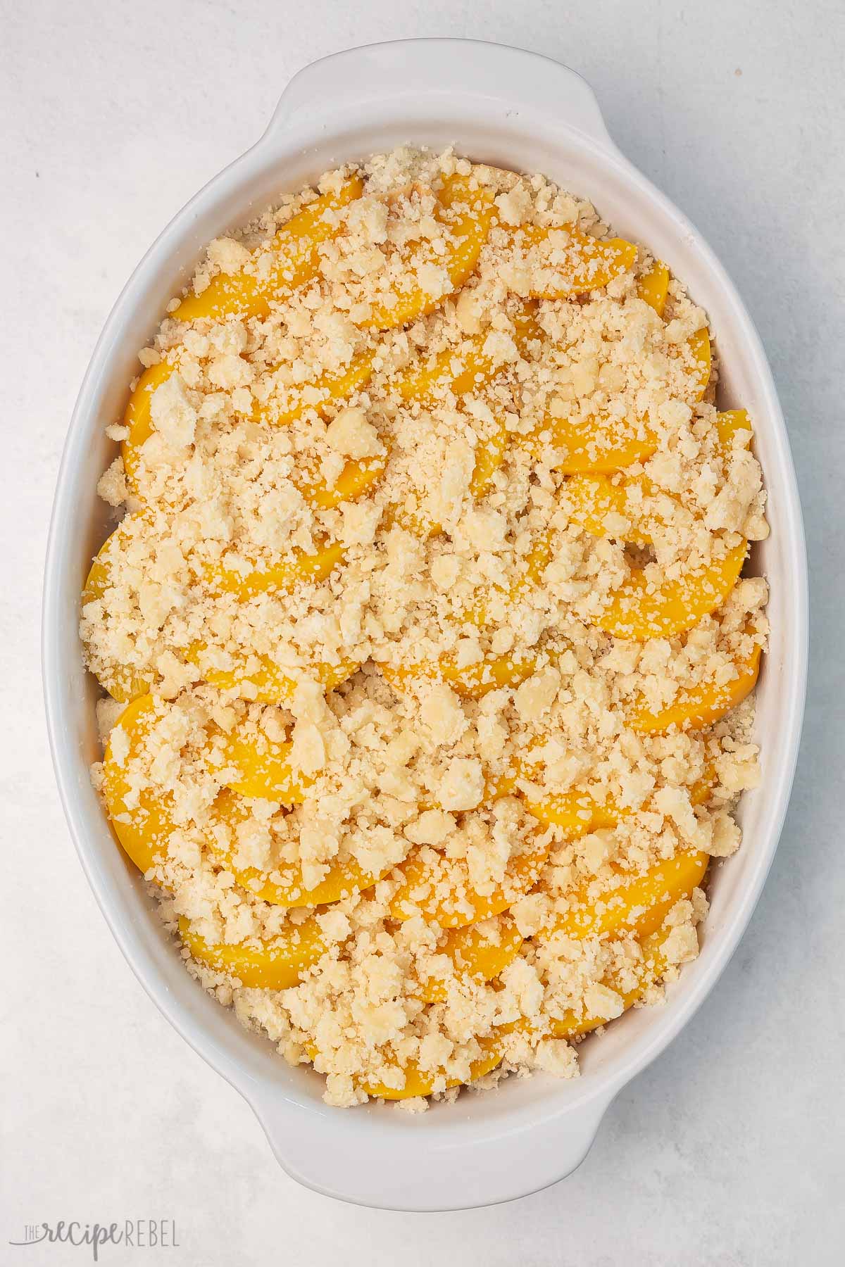 Top view of a baking dish with cobbler topping in a single layer on top. 