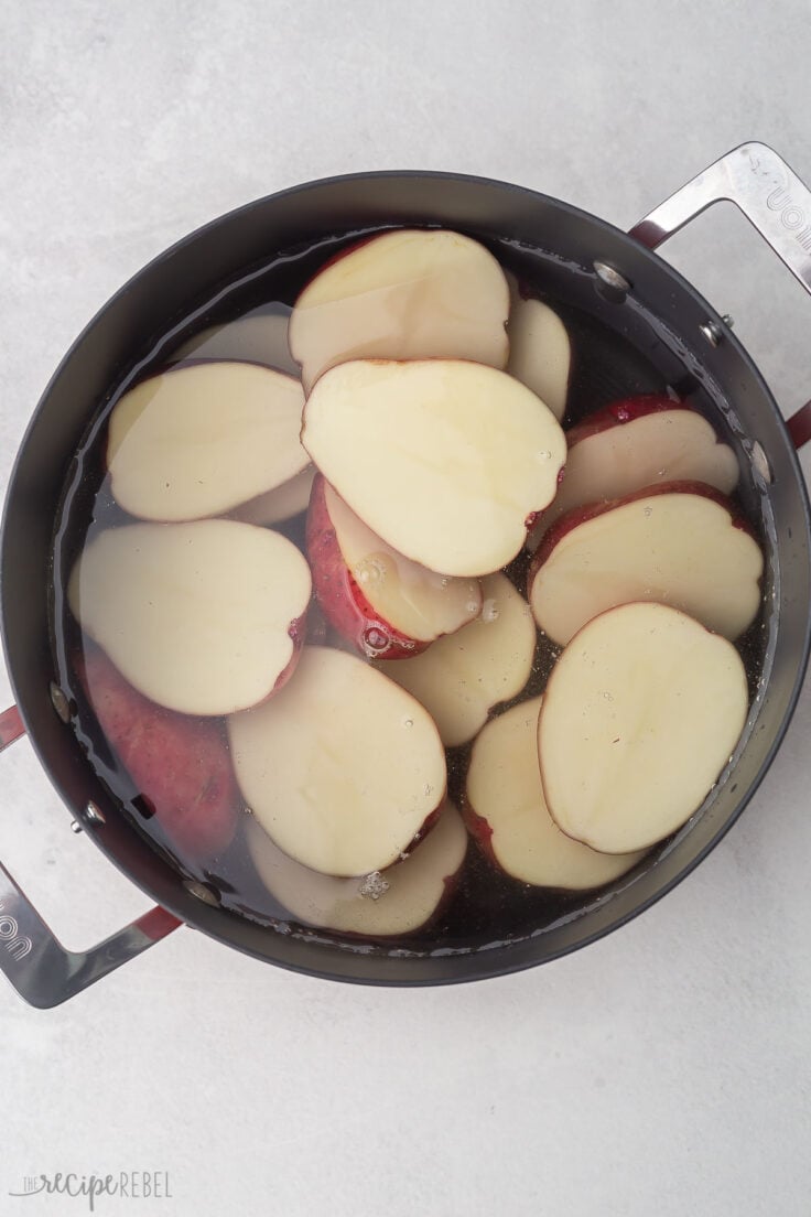 large pot filled with water and halved potatoes.