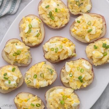 close up view of potato salad bites topped with sliced green onions.