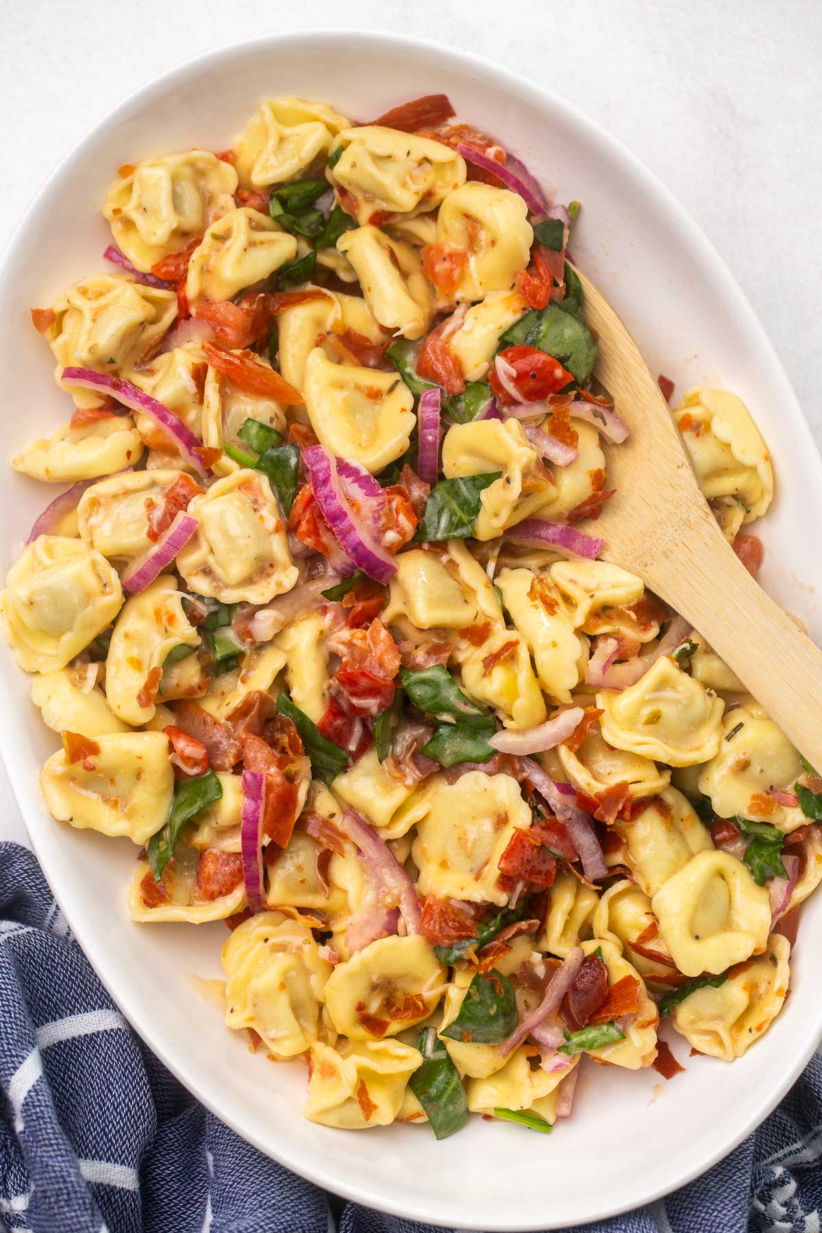 overhead shot of a white platter filled with tortellini pasta salad.