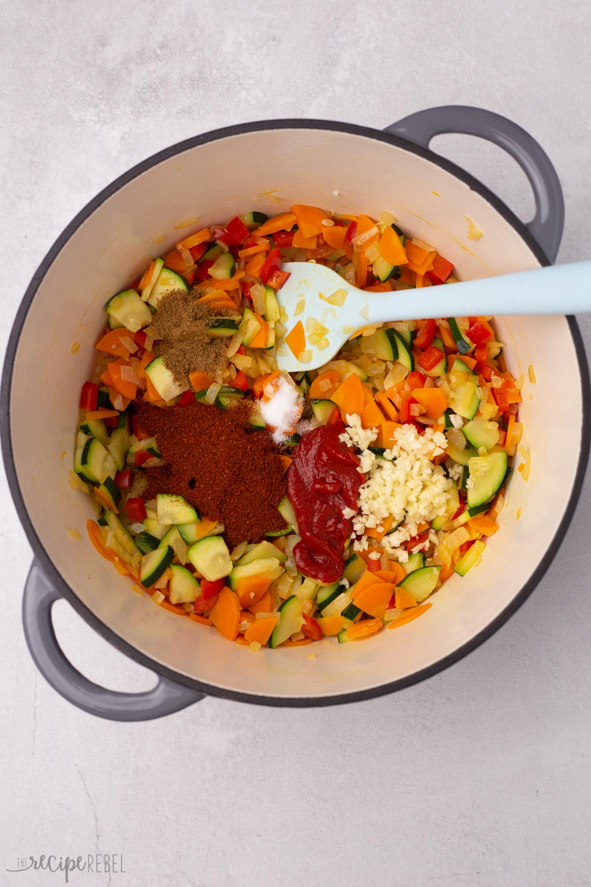 Top view of vegetables and spices in big dutch oven.