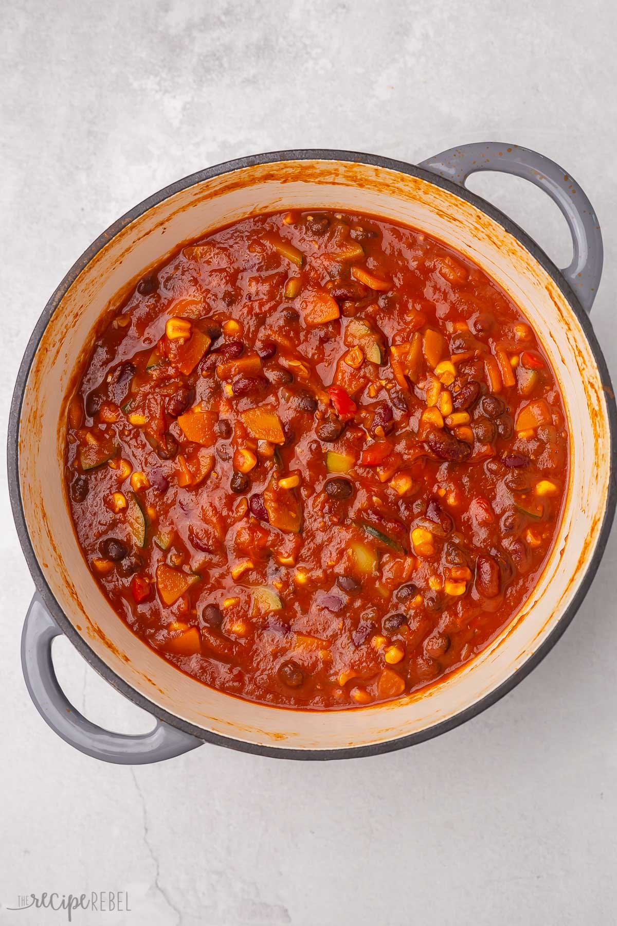 Top view of cooked vegetarian chilli in grey dutch oven.