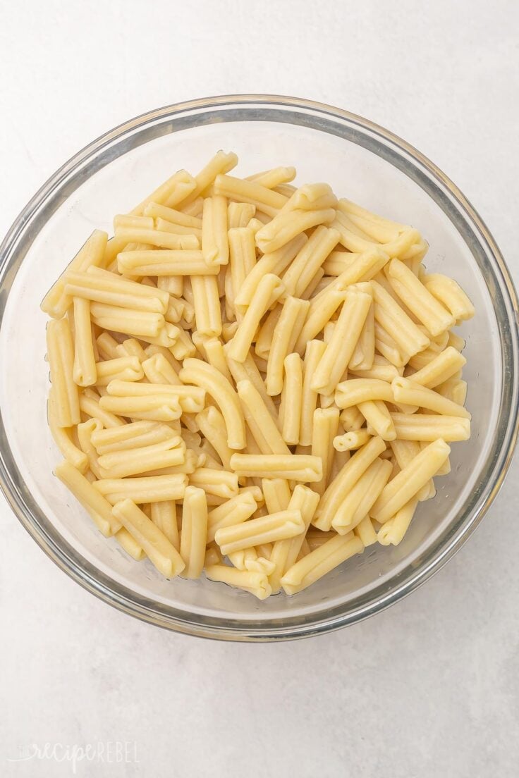 Top view of glass mixing bowl with cooked pasta in it.