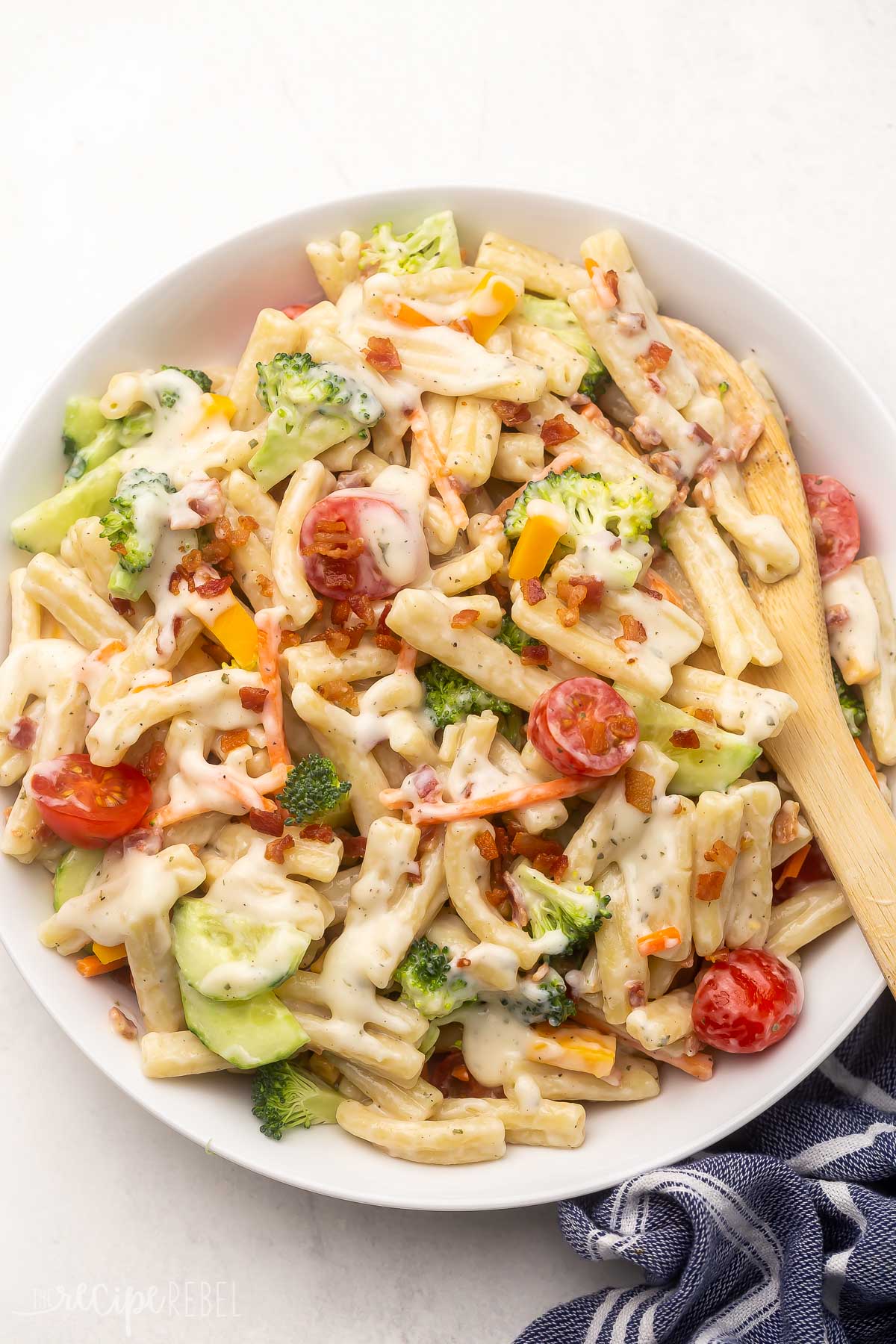 Top view of Bacon Ranch Pasta Salad in a white bowl on a white table. 