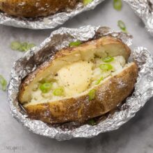 Close up of a baked potato from the grill in a foil packet.