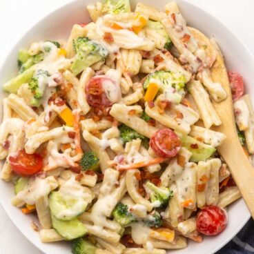 Top view of Bacon Ranch Pasta Salad in a white bowl on a white table.