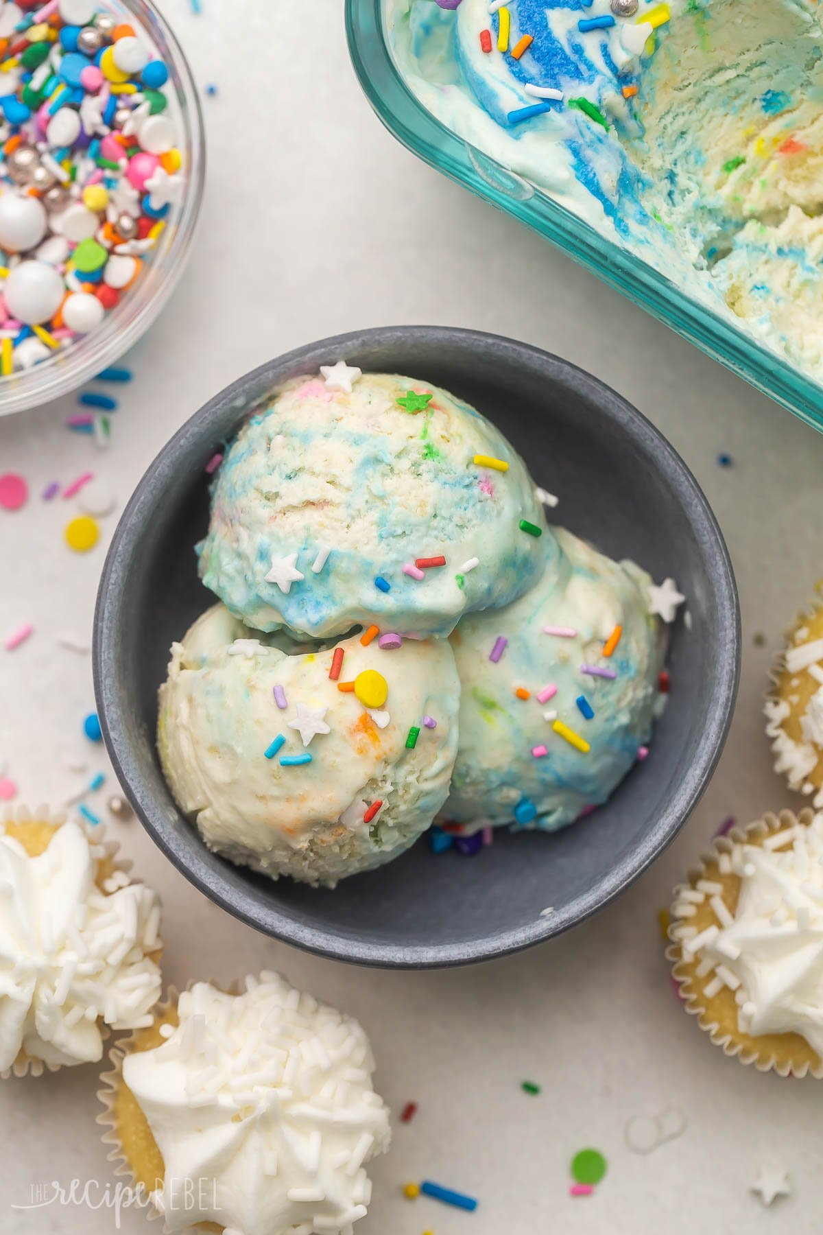 Top view of a bowl with three scoops of birthday cake ice cream in it. 