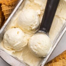 Top view of No Churn Ice Cream in an ice cream tray being scooped with an ice cream scoop.