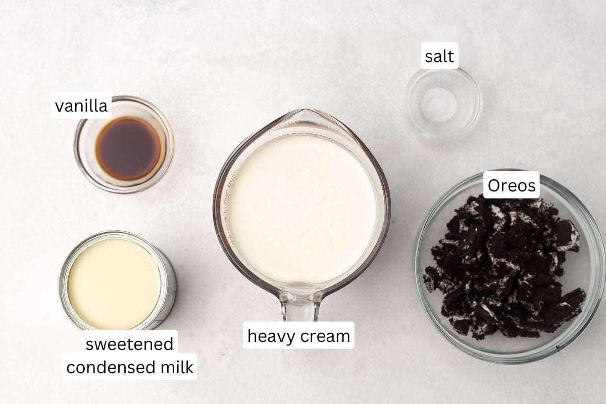 Top view of ingredients needed to make Oreo ice cream in small bowls on a worktop. 