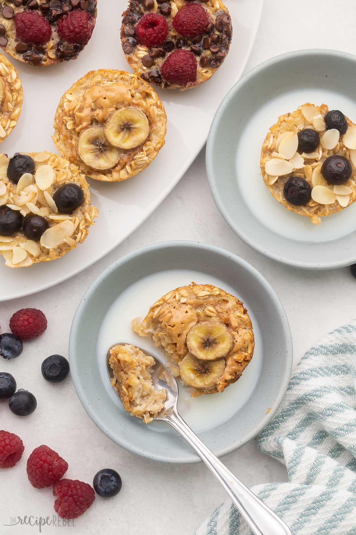 light blue bowls with baked oatmeal cups and milk in them.