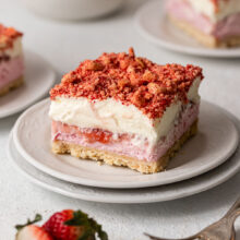 close up of a piece of strawberry shortcake ice cream bars on a white plate.