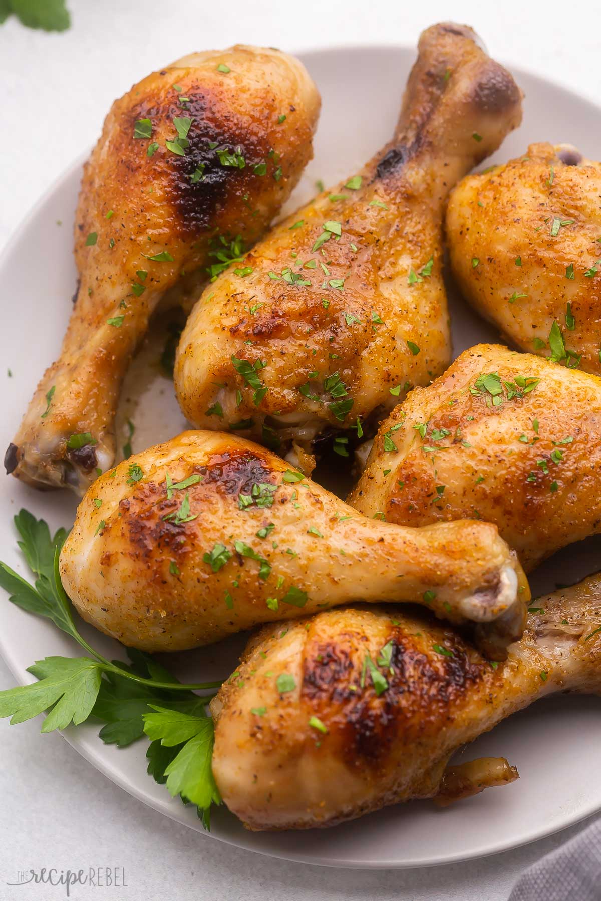 grey plate full of baked chicken drumsticks.