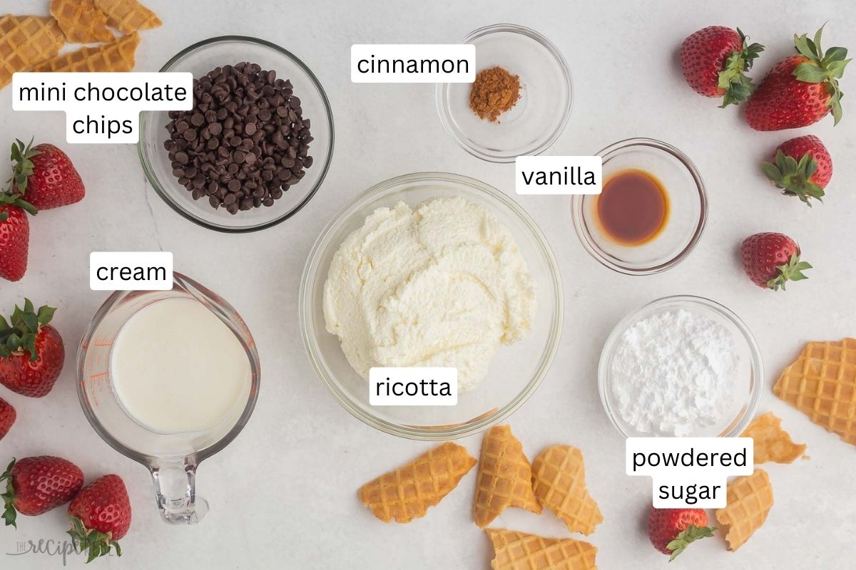 ingredients for cannoli dip in glass bowls on grey surface.