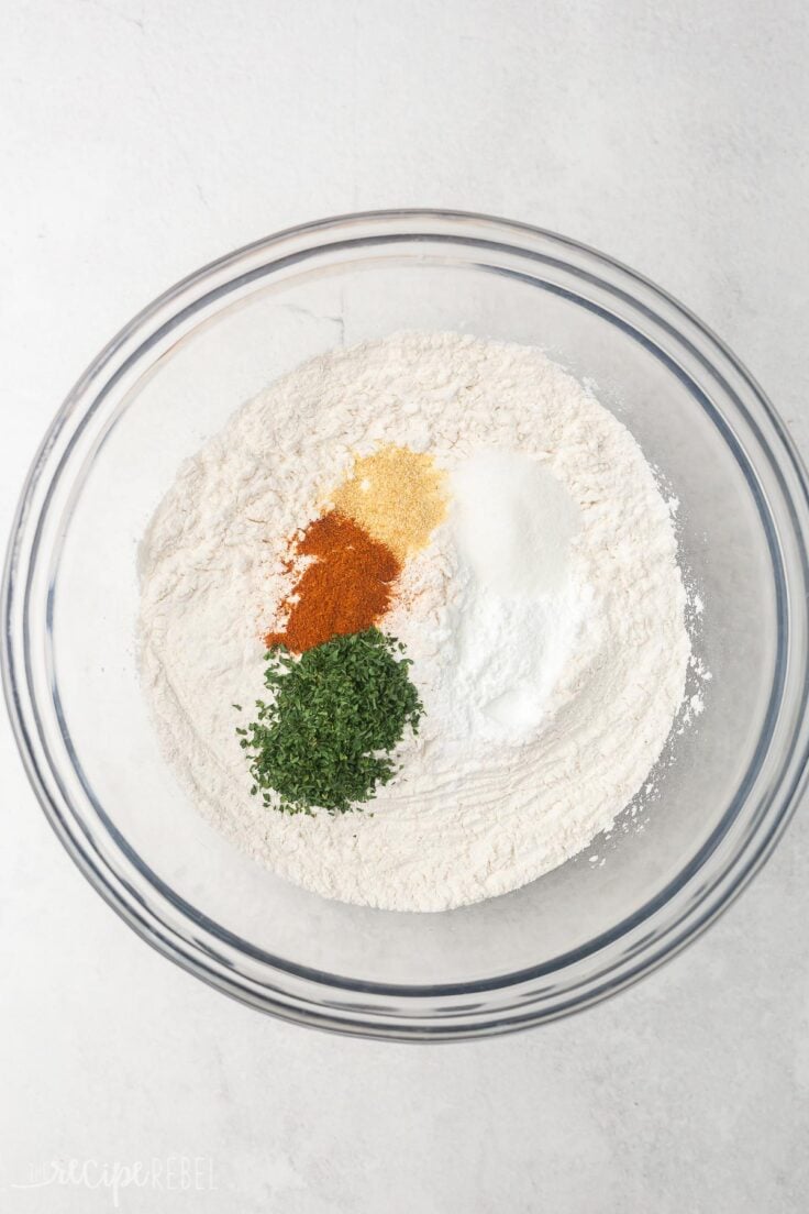 dry ingredients for cheddar bay biscuits, unmixed in glass bowl.