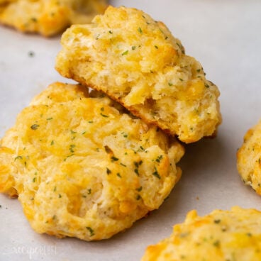 close up view of two cheddar bay biscuits on a grey surface.