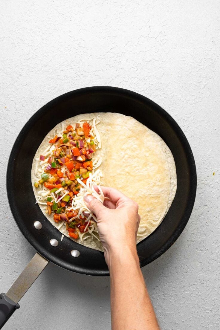 a black frying pan with a cheese quesadilla being made in it.