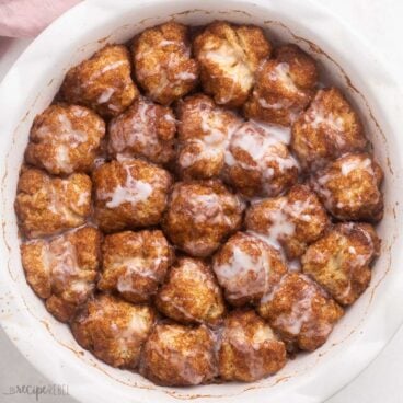 close up view of a round white dish filled with cinnamon roll bites.
