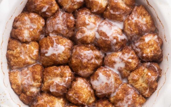 close up view of a round white dish filled with cinnamon roll bites.