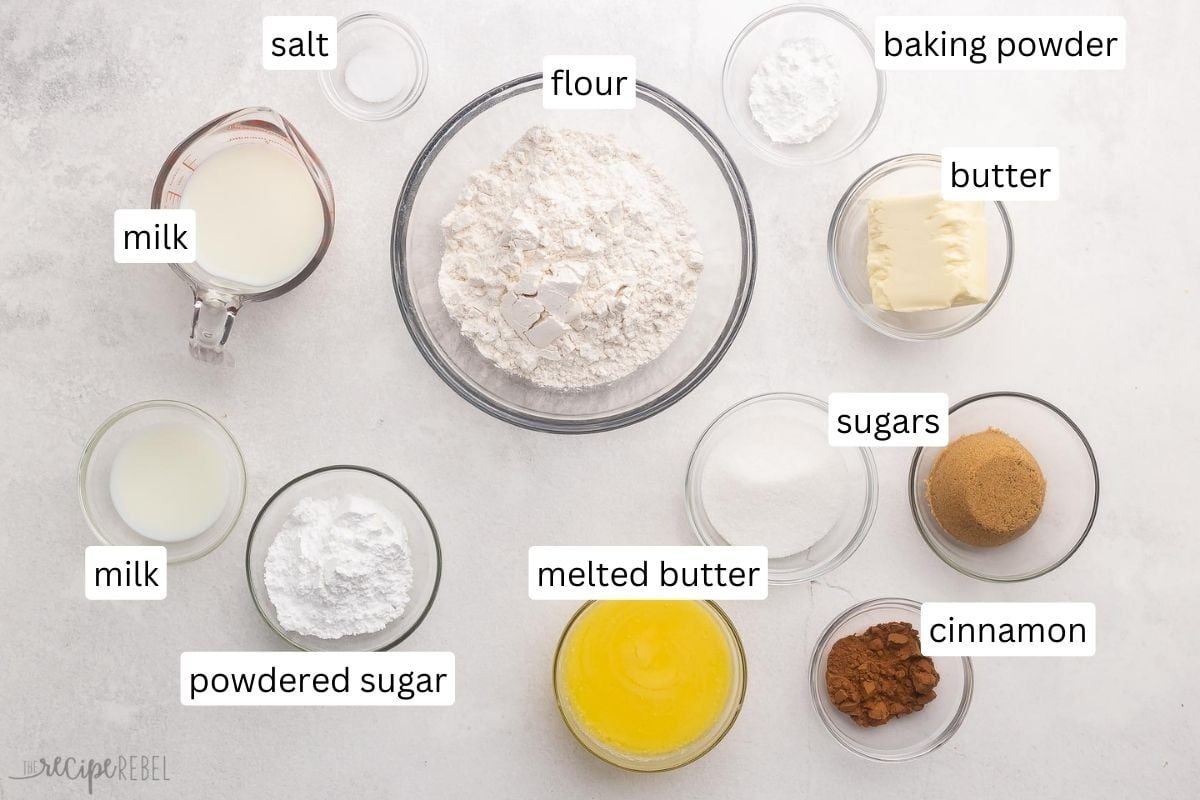 ingredients for cinnamon roll bites in glass bowls on grey surface.