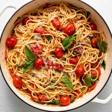 overhead view of a full pot of tomato basil pasta garnished with parmesan.