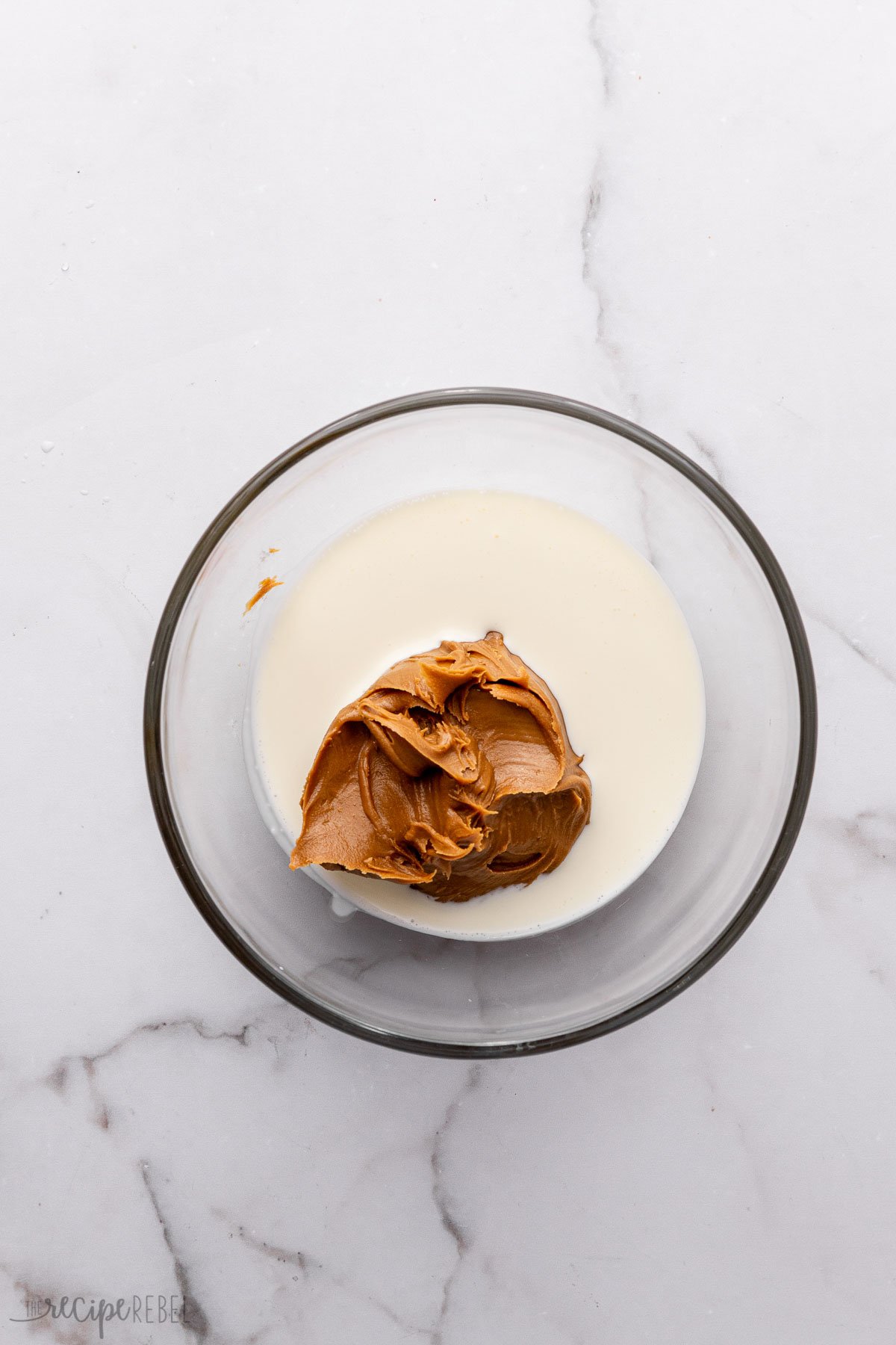 glass bowl on grey surface with cream and cookie butter in it.