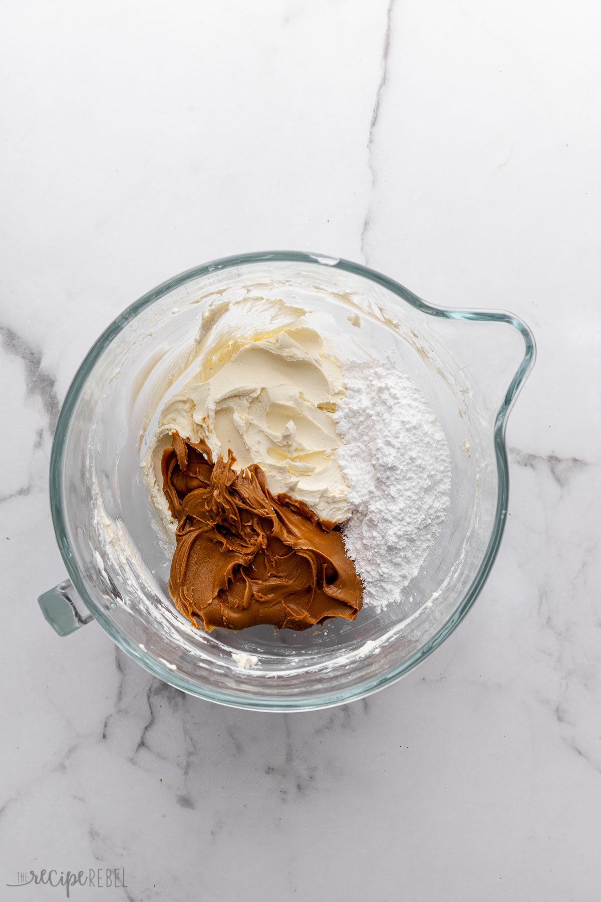 glass measuring cup filled with unmixed ingredients.