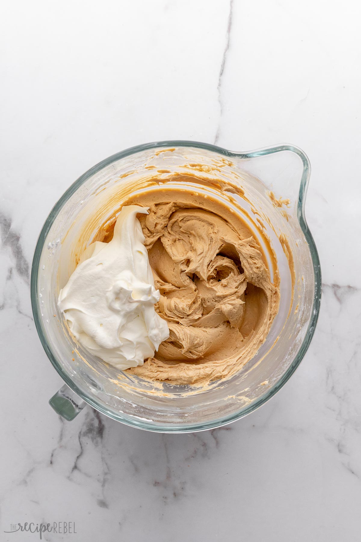 overhead shot of mixed ingredients with whipping cream on top.