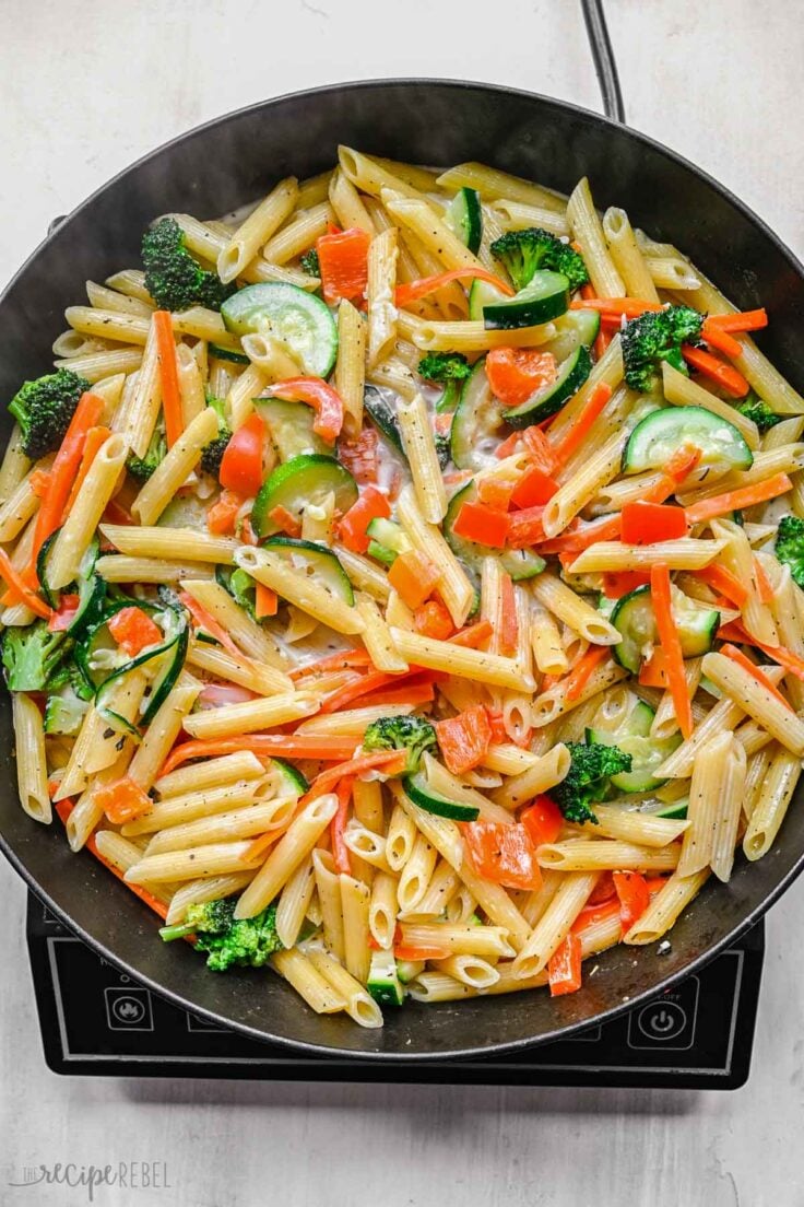 close up of mixed pasta and vegetables in frying pan.