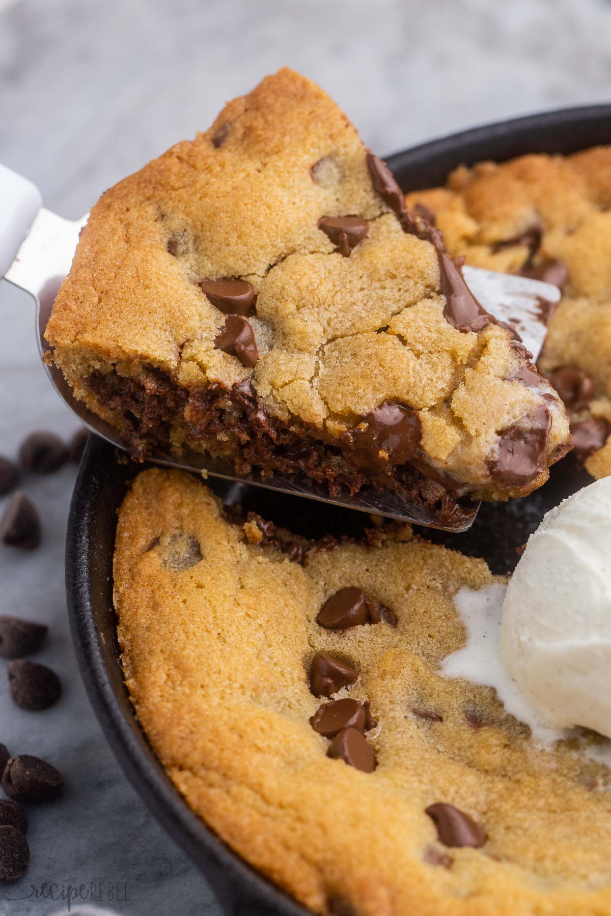 a slice of skillet cookie coming out of cast iron pan.