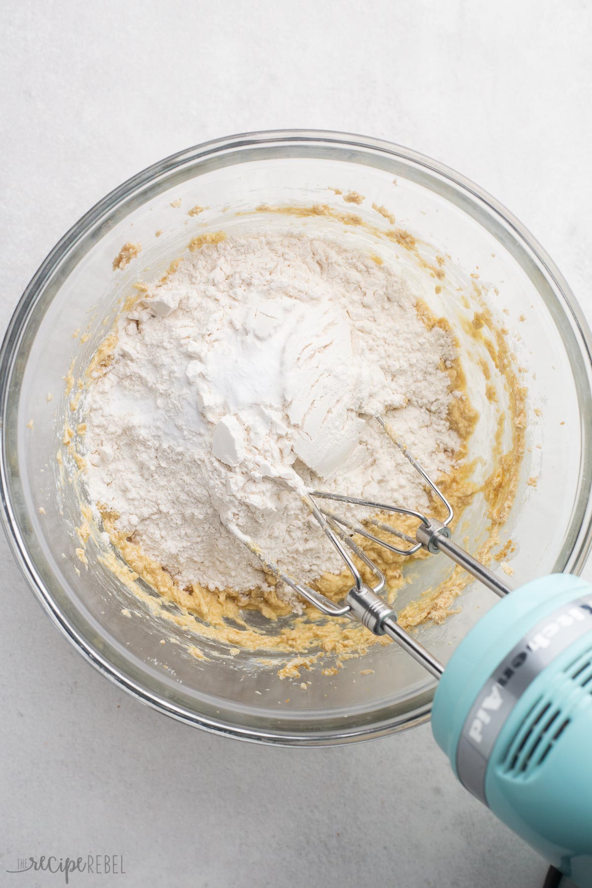 dry ingredients added to mixing bowl with mixer beside.