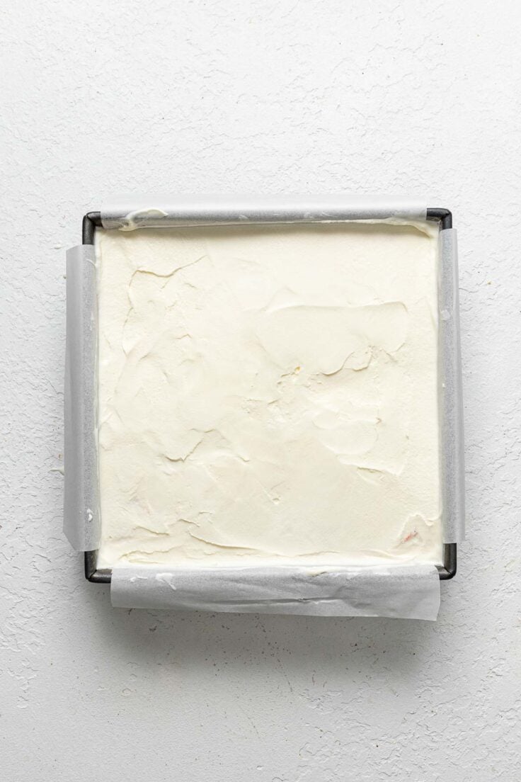 cake pan with vanilla ice cream layer spread evenly.