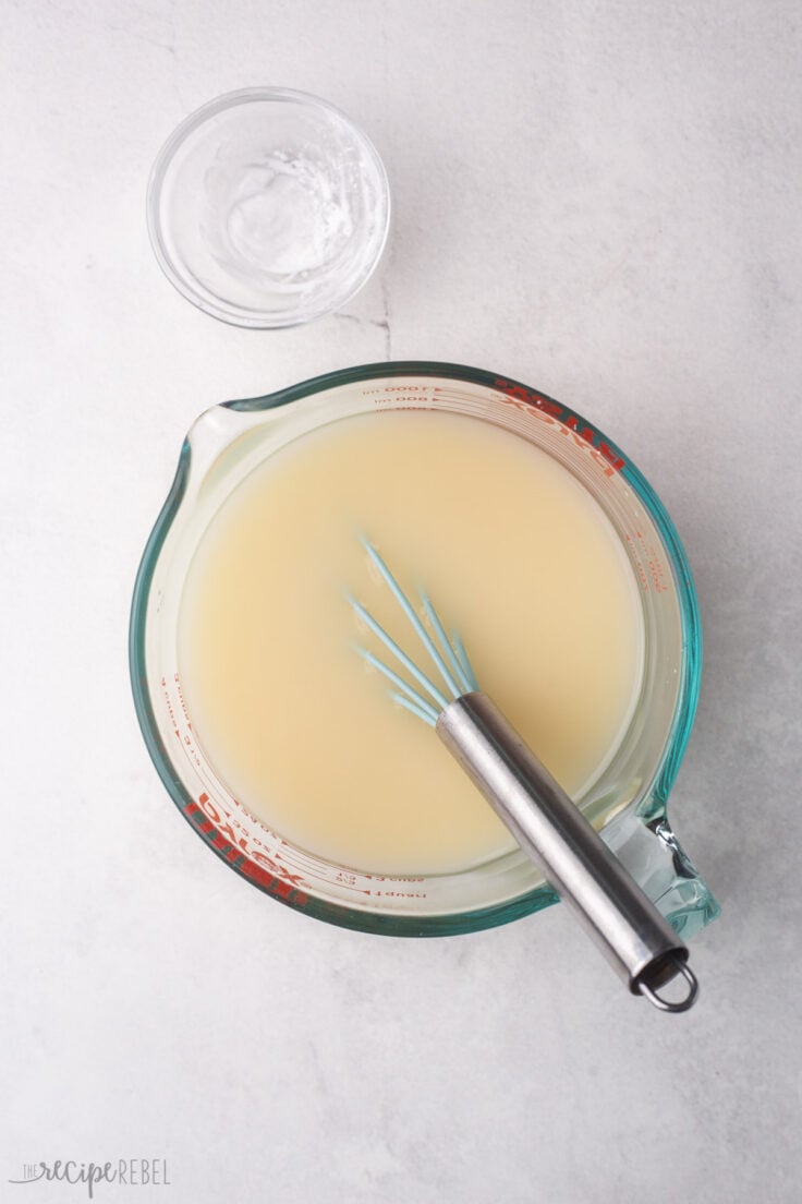 measuring cup with broth and cornstarch whisked together.