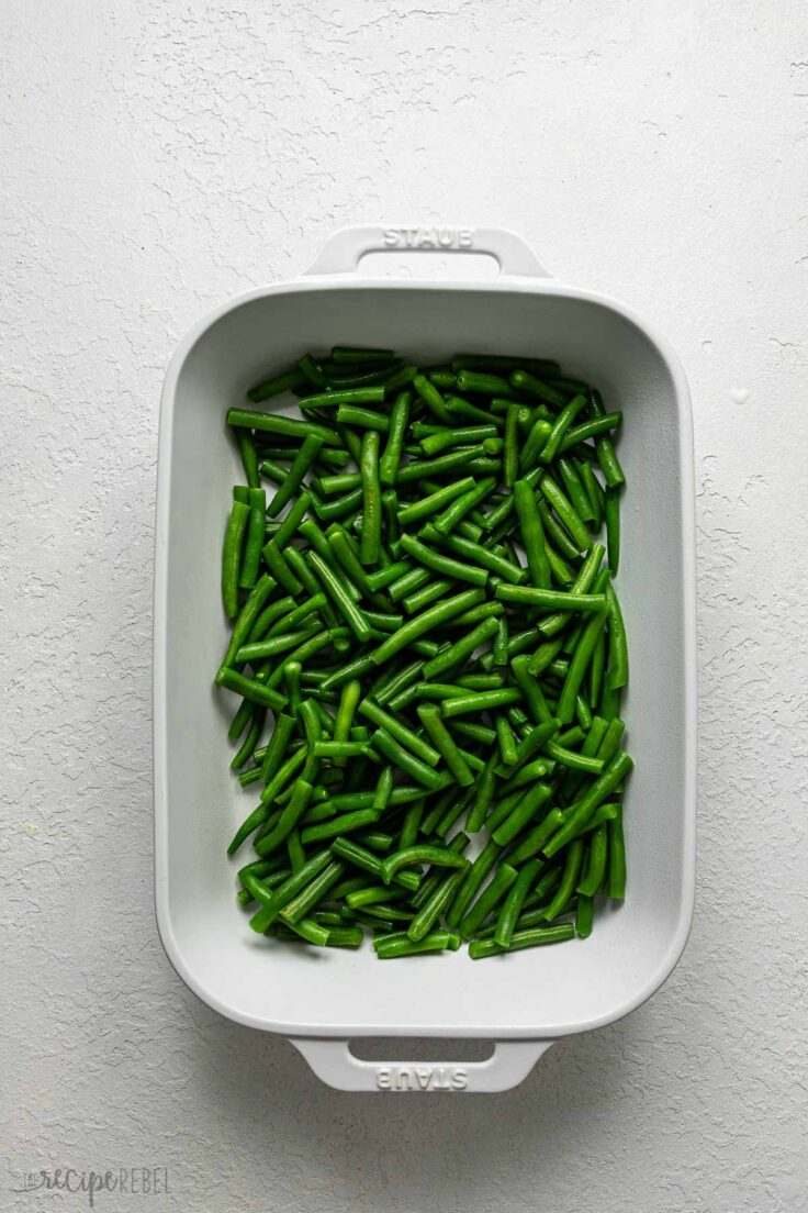 white baking dish filled with green beans.