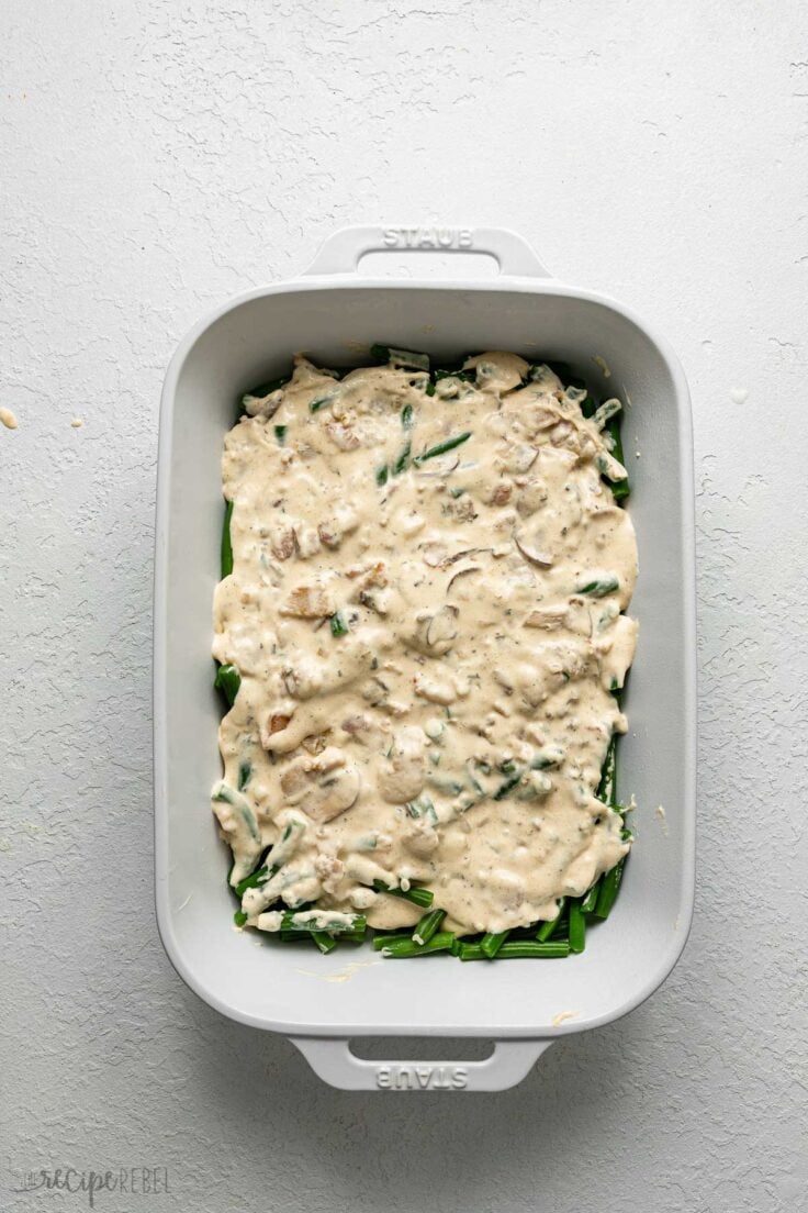 white baking dish of green beans with creamy topping.