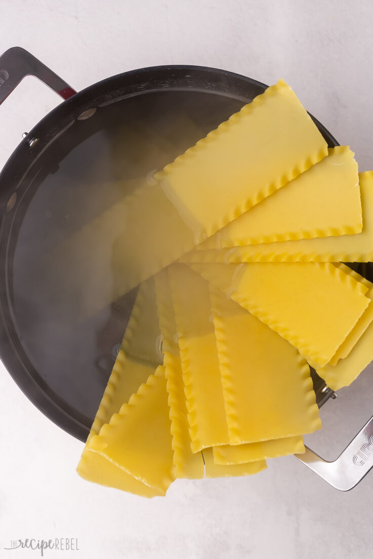 large pot of water with uncooked lasagna noodles in.