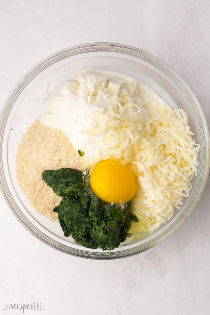 a glass bowl of unmixed ingredients on a light grey surface.