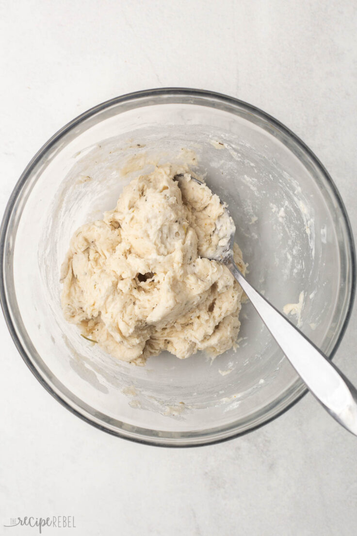 glass bowl with spoon and mixed dough in it.