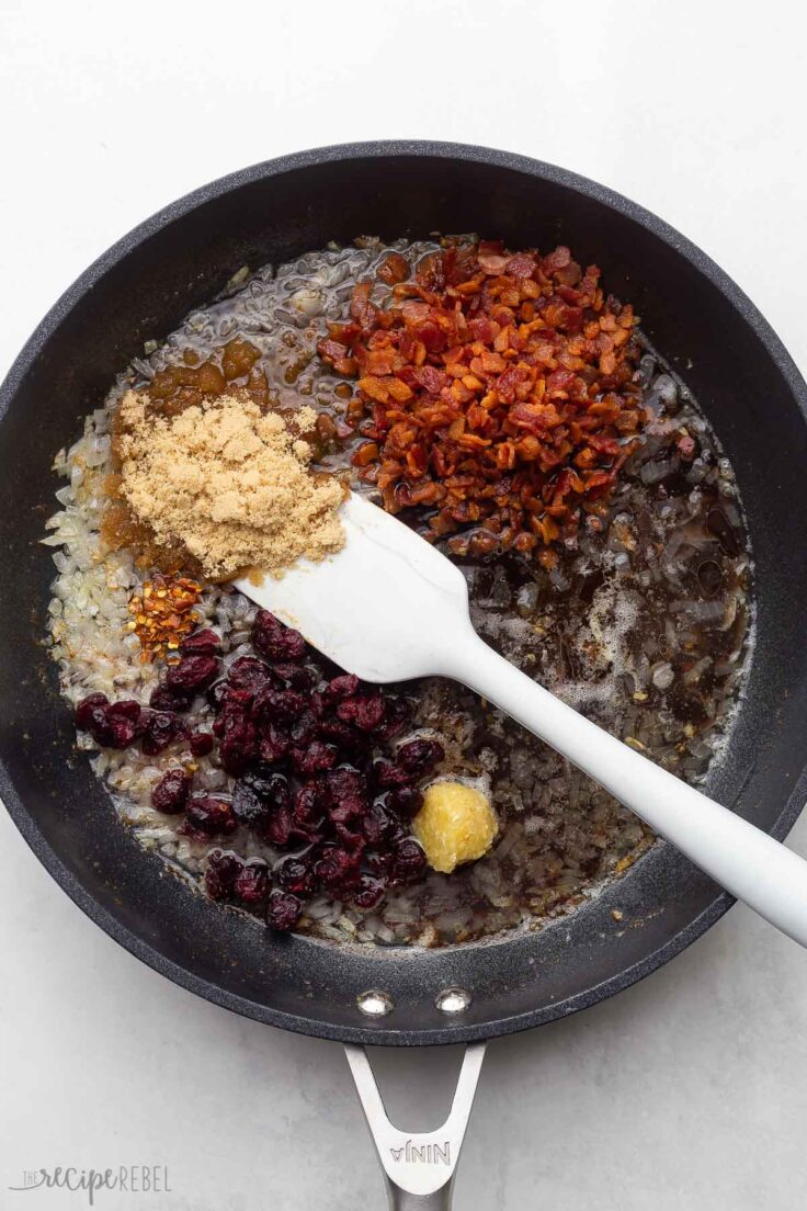 black frying pan with unstirred cranberry bacon sauce ingredients