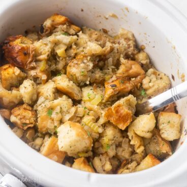 close up of a white crockpot full of stuffing.