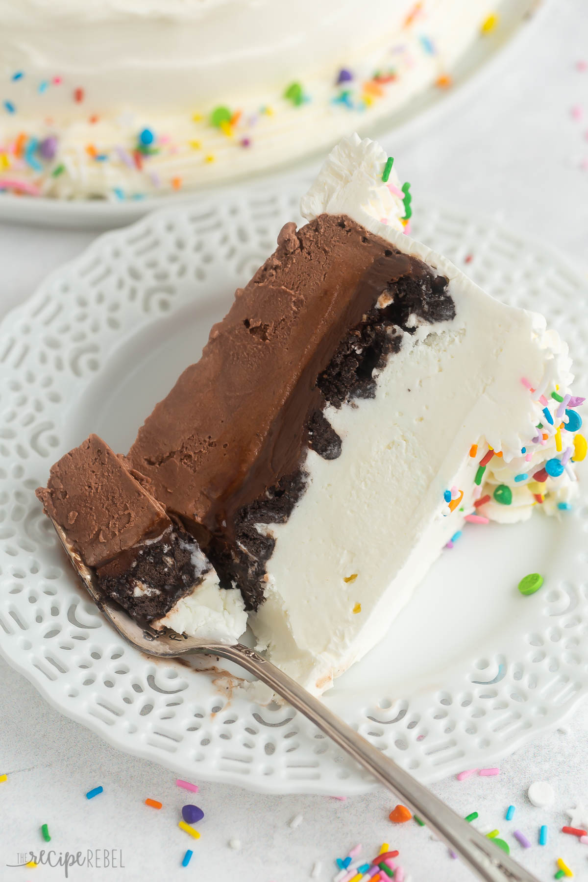 piece of ice cream cake on white plate with fork.