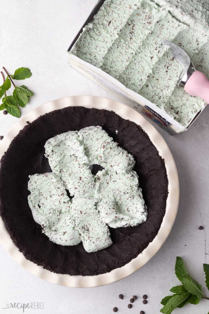 mint chip ice cream being scooped into chocolate crust.