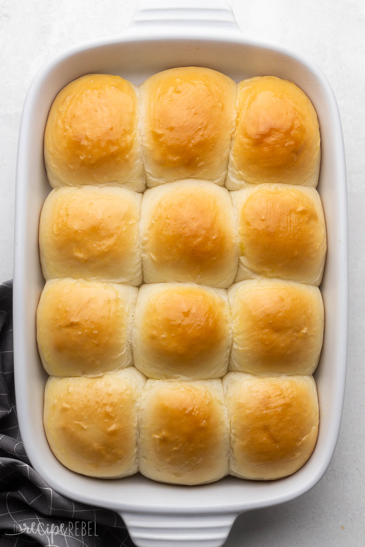 white baking dish full of baked dinner rolls.