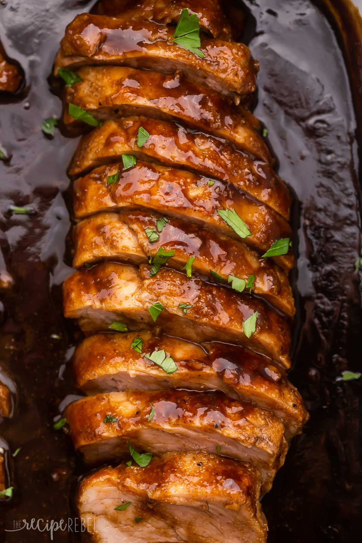close up of sliced pork tenderloin in sauce.